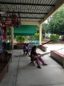 オアハカの近郊の村（セント・トーマス・アリエラ）で編み物を売りながら市場で物を販売している女性
